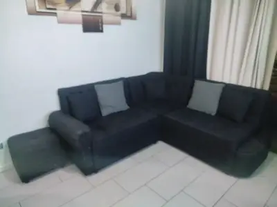 Sofá esquinero negro con puff incluido - miniatura 2