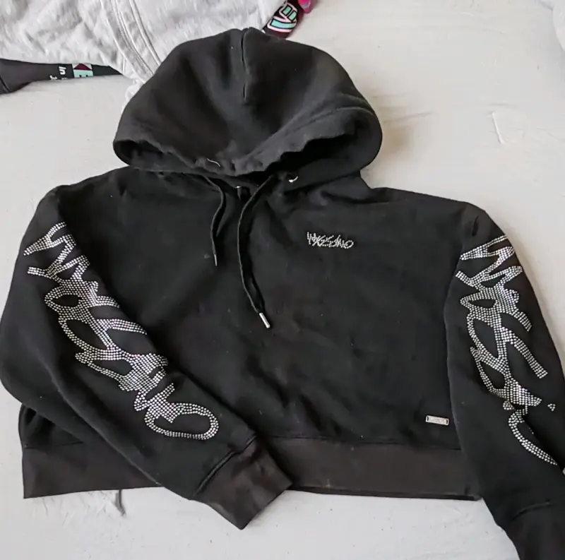 Polerón negro con capucha y diseño brillante