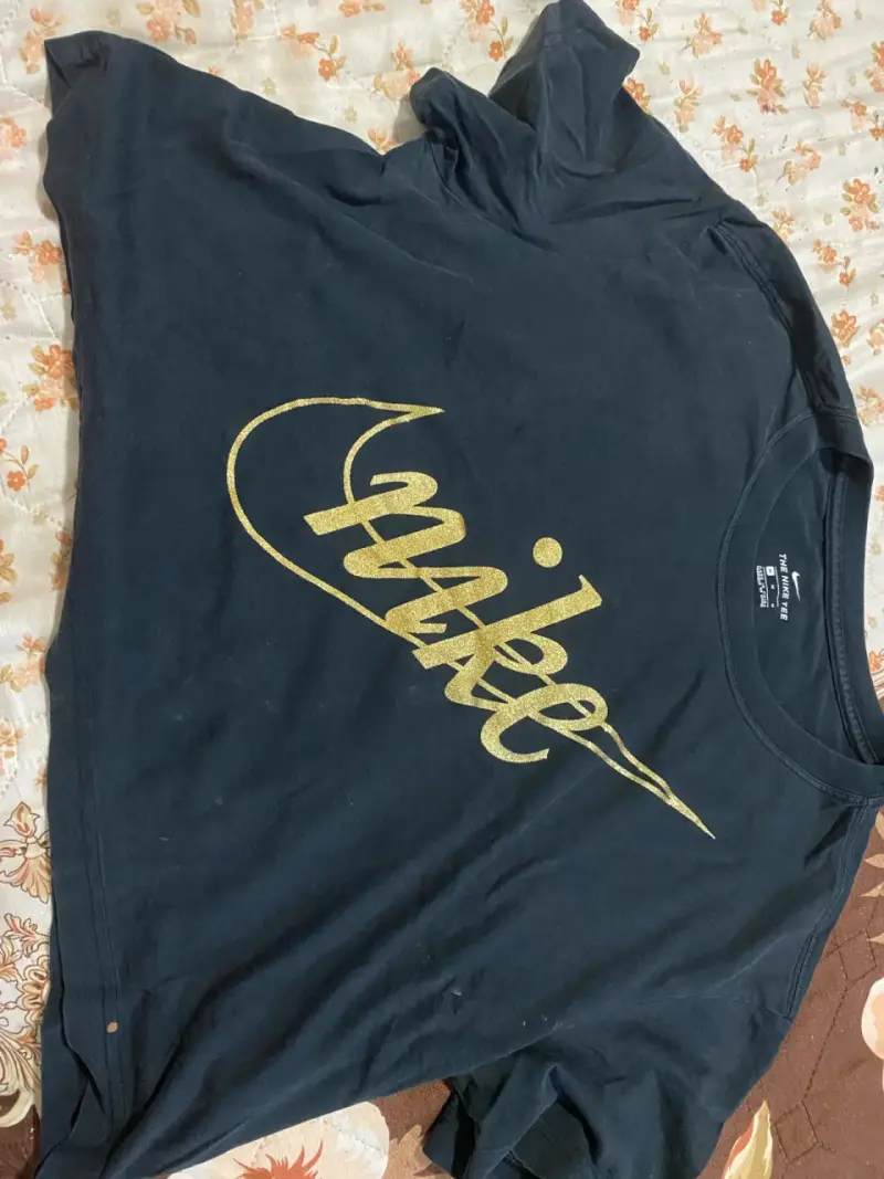 Polera Nike negra con logo dorado