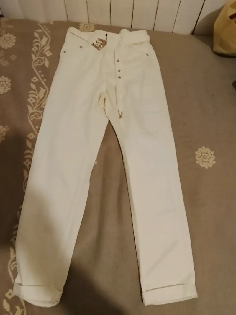Pantalones blancos con cinturón dorado