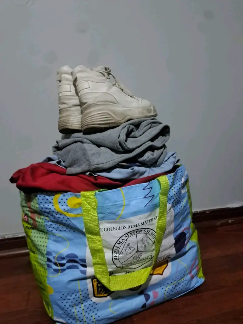 Bolsa de ropa y zapatillas blancas usadas - 1