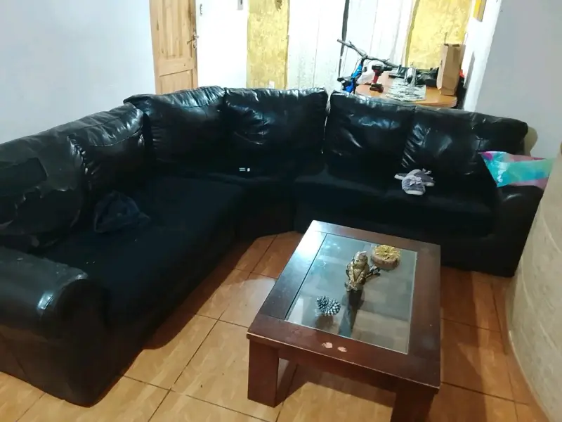 Sofá seccional de cuero negro usado