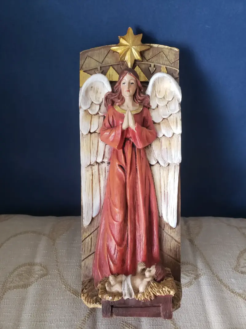 Figura de ángel con niño Jesús en pesebre