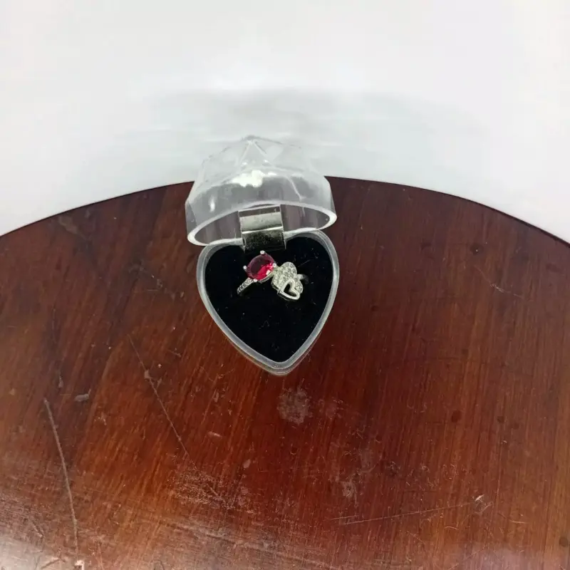 Anillo de plata con piedra roja en estuche de corazón