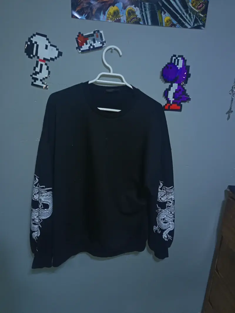 Polerón negro con diseño de dragón en mangas