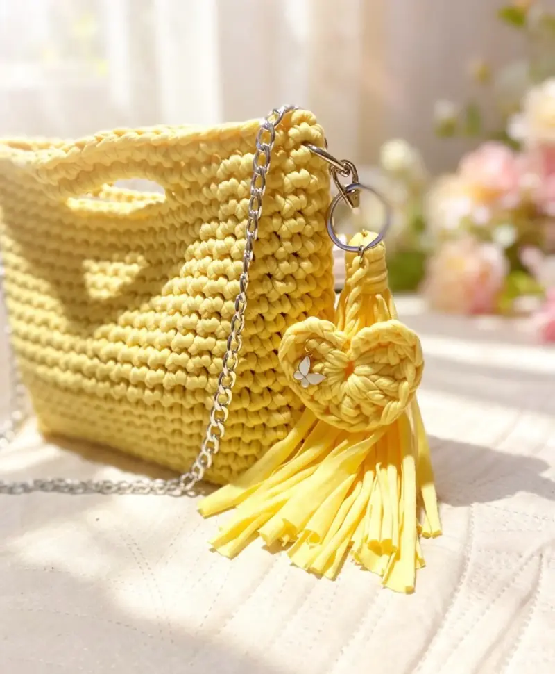Bolso tejido amarillo con cadena y llavero de cor - 1