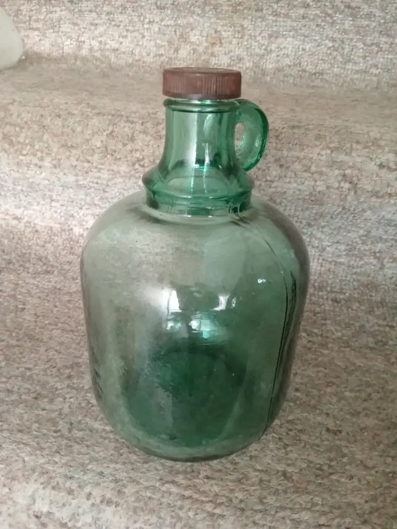 Botella de vidrio verde con tapa de rosca