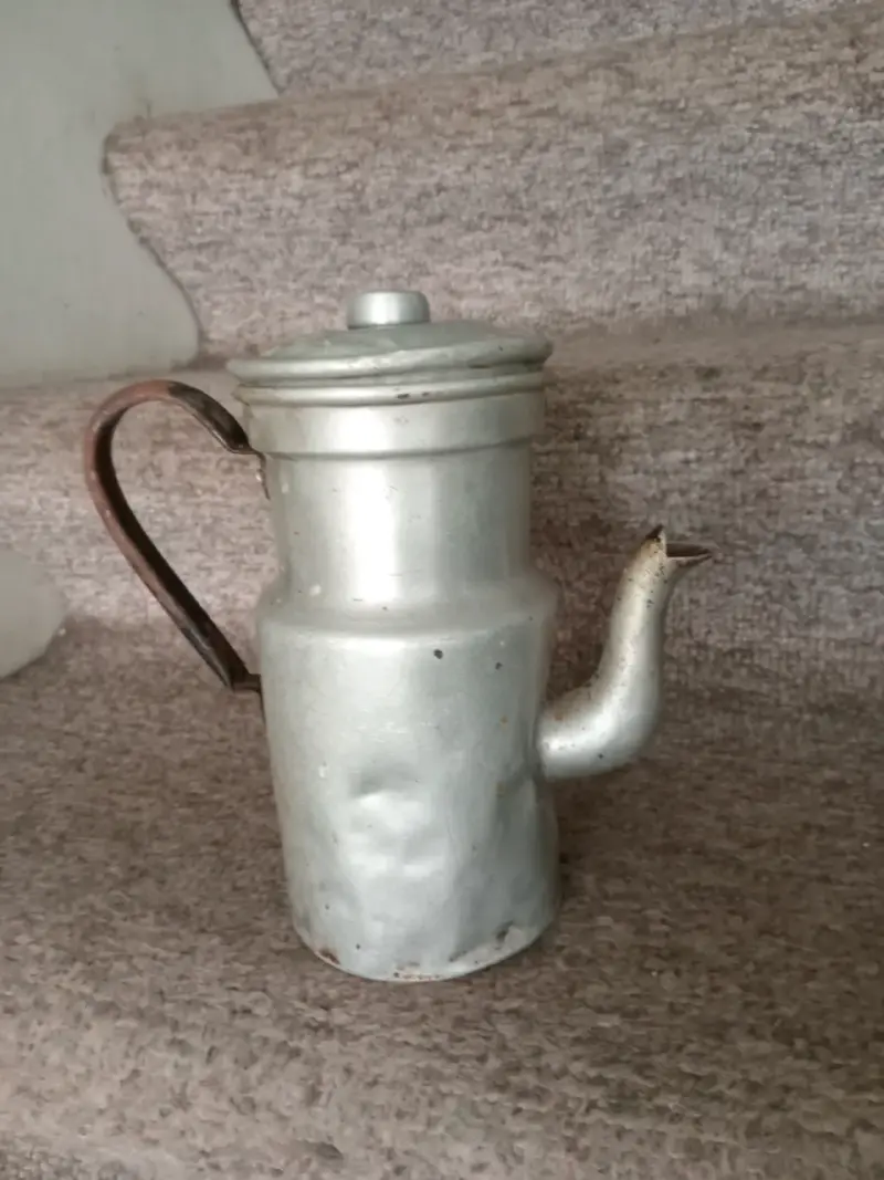 Antigua tetera de aluminio con asa de madera