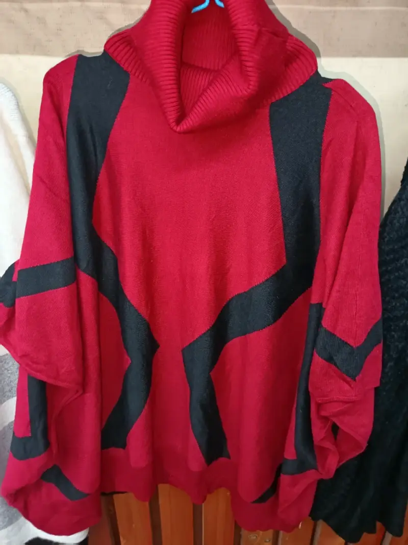 Poncho rojo con cuello alto y diseño geométrico