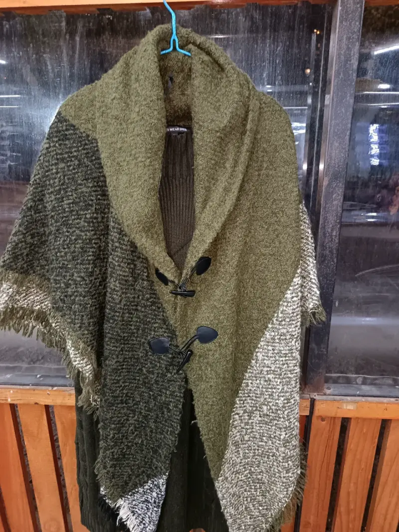 Poncho de lana verde con botones decorativos