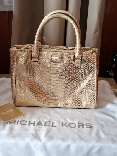 Bolso Michael Kors dorado con textura de serpiente - miniatura 1
