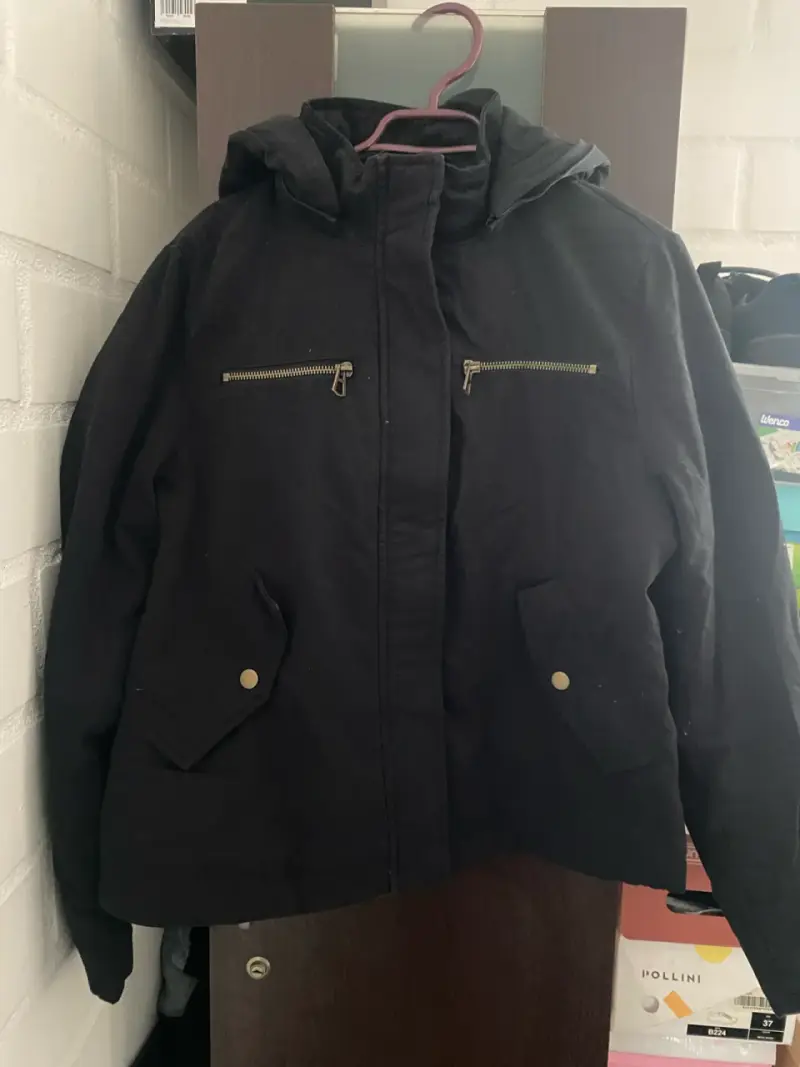Chaqueta negra con capucha y bolsillos