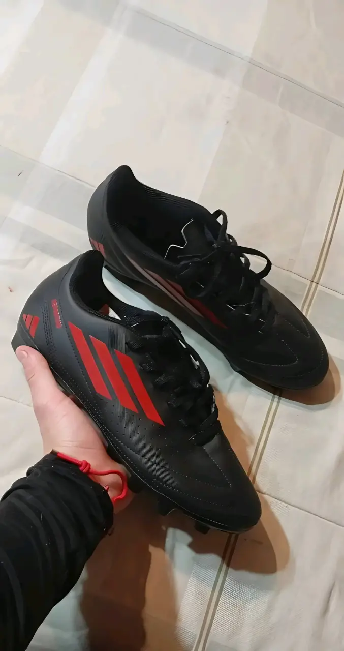 Zapatillas de fútbol negras con detalles rojos
