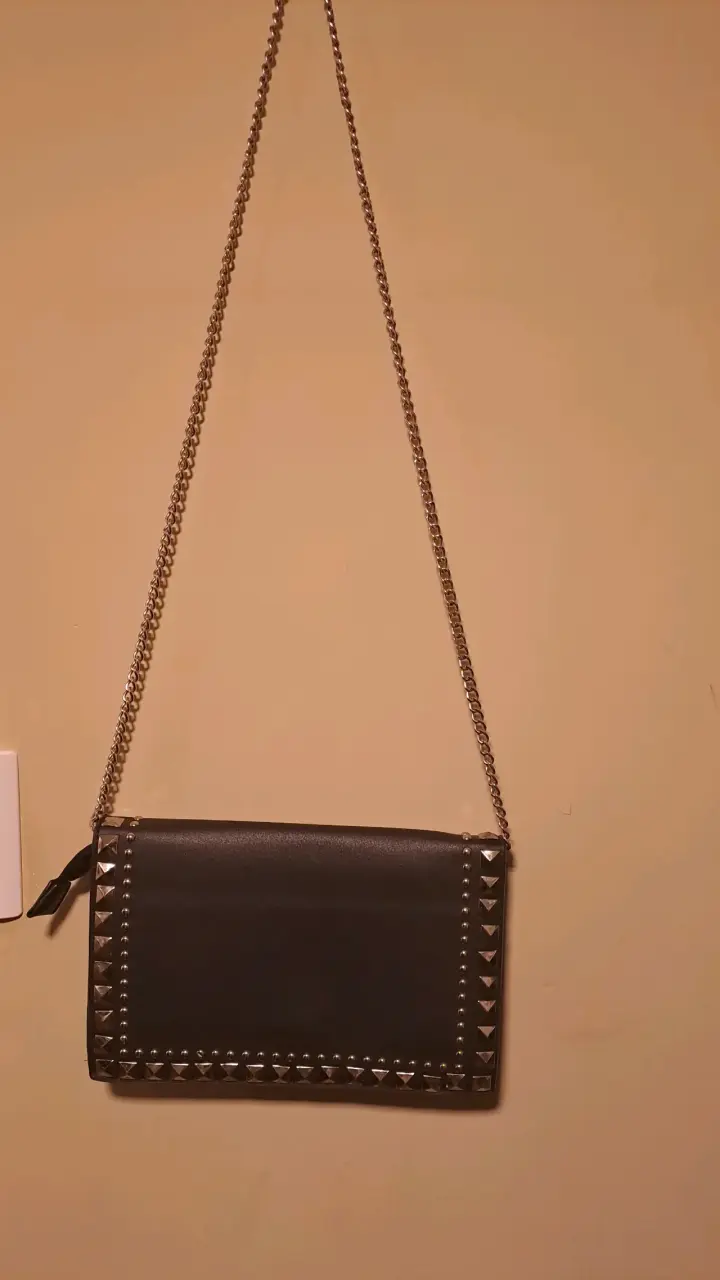Cartera negra con tachas y cadena
