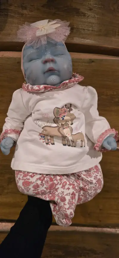 Muñeca reborn azul con ropa floral - miniatura 1