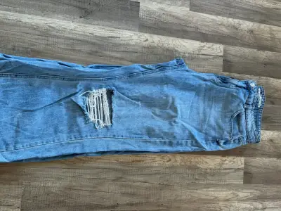 Jeans de mezclilla azul con diseño desgastado - miniatura 1