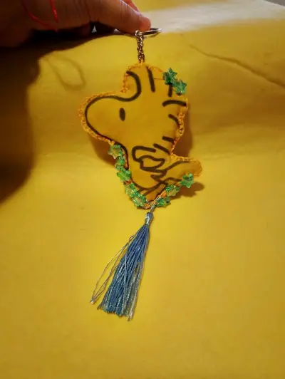 Llavero de tela amarillo con borla azul - miniatura 1