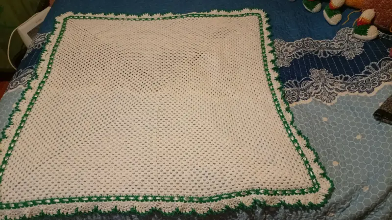 Manta tejida a crochet beige con borde verde