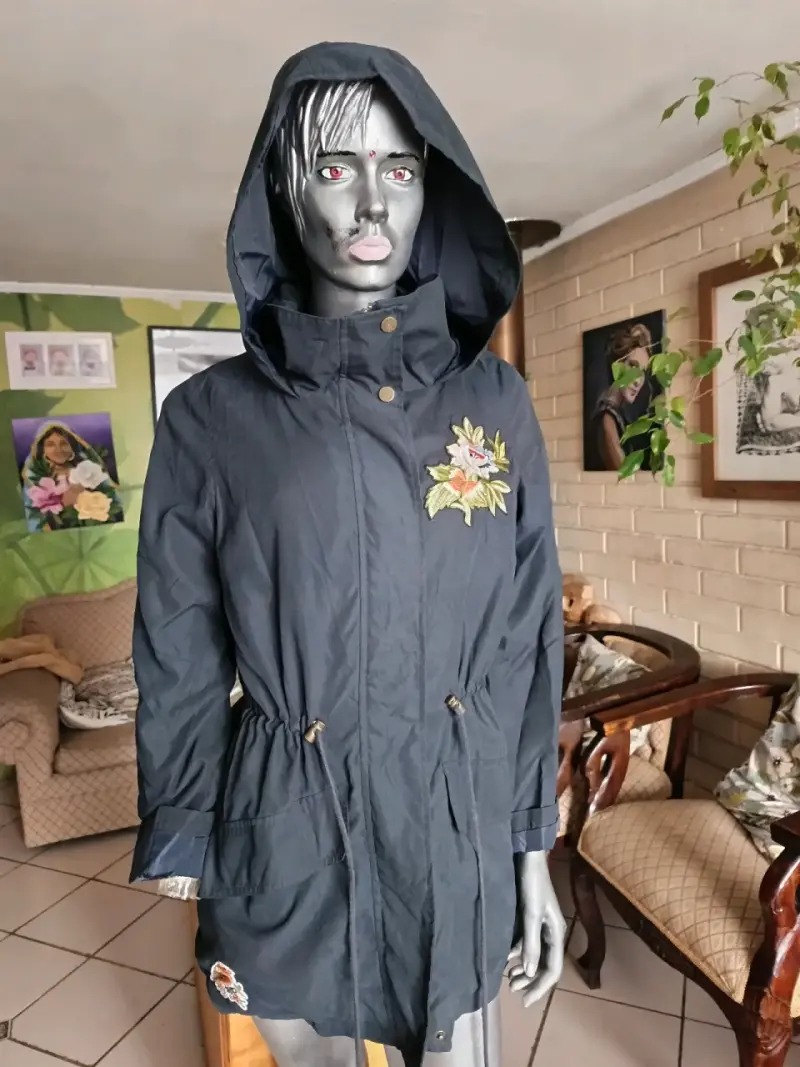 Parka negra con capucha y bordado floral