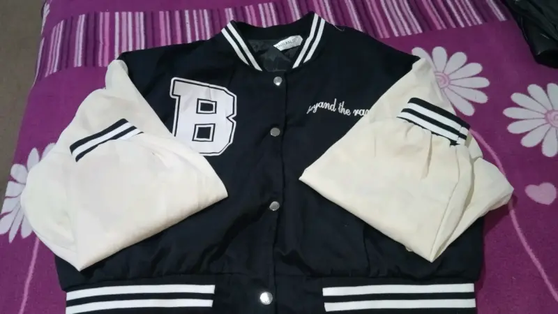 Chaqueta varsity negra y blanca estilo universitario