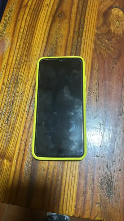 Smartphone con funda amarilla en buen estado - miniatura 1