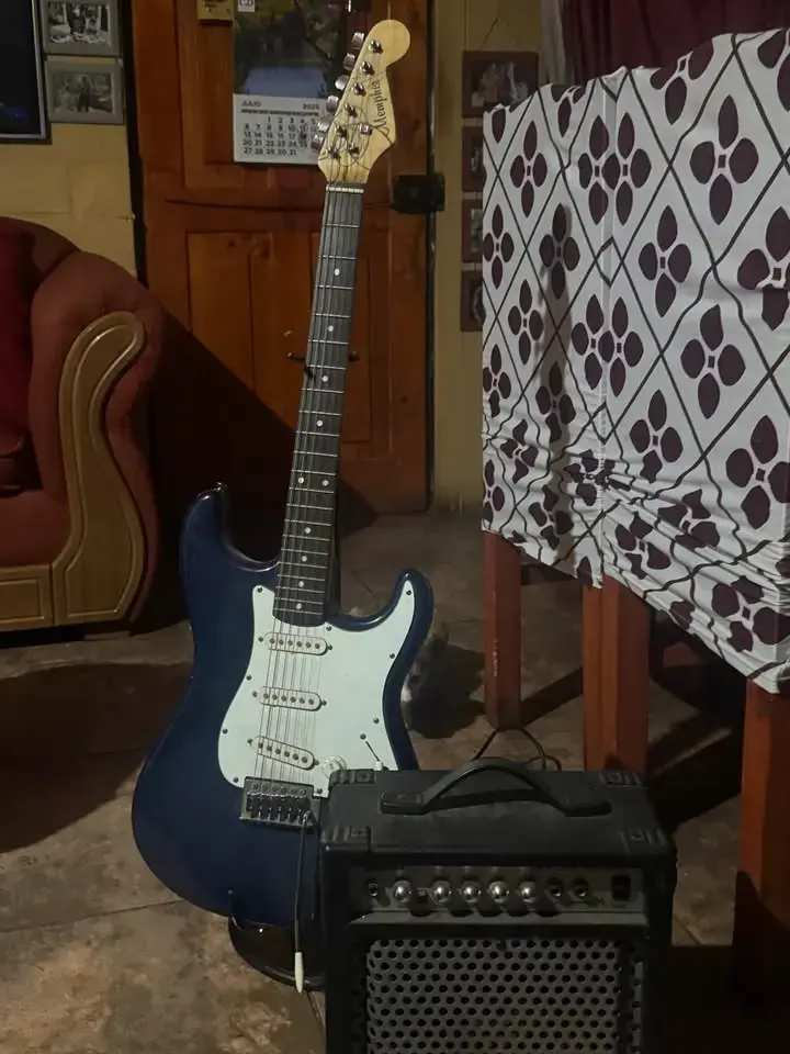 Guitarra eléctrica azul con amplificador