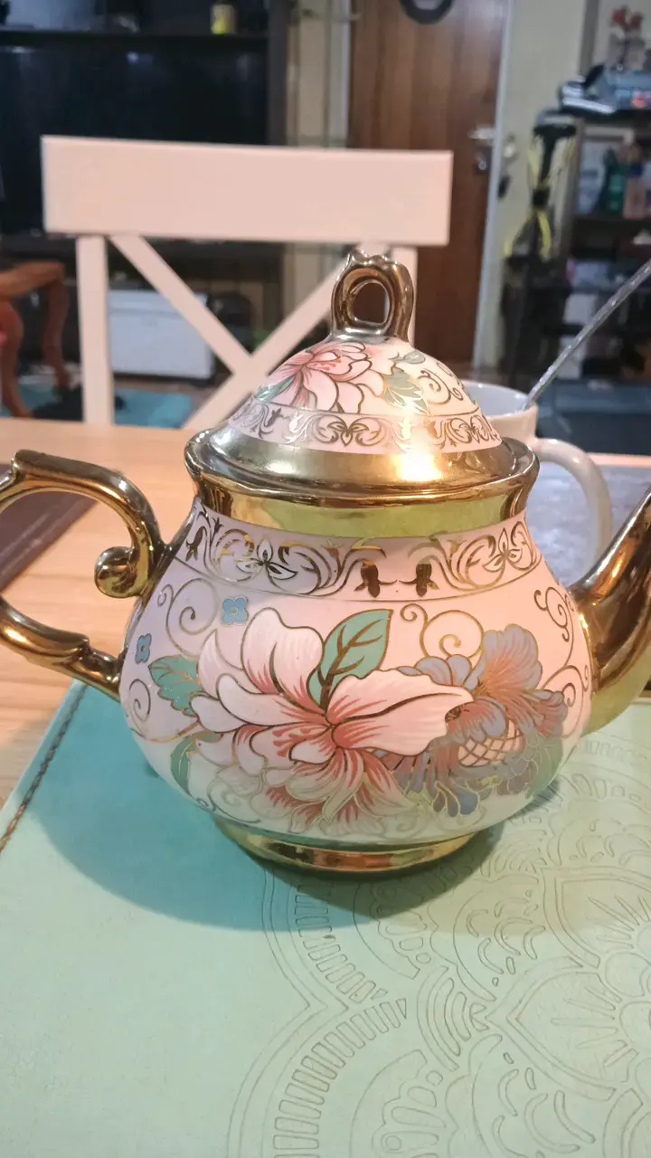 Tetera de porcelana con diseño floral y detalles dorados