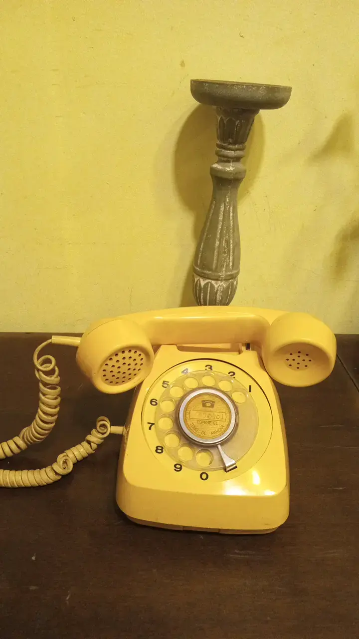 Teléfono antiguo de disco amarillo vintage - 1