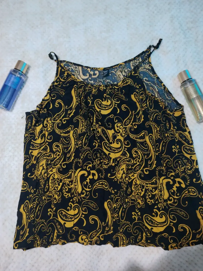 Blusa sin mangas estampada en negro y dorado