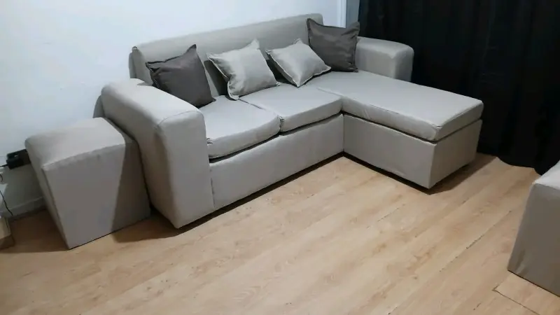 Sofá seccional beige con cojines decorativos