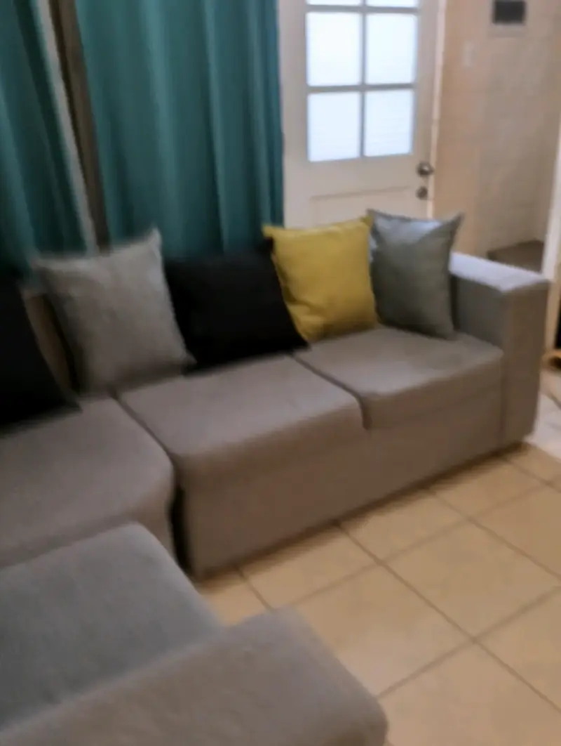 Sofá seccional gris con cojines decorativos - 2