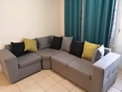 Sofá seccional gris con cojines decorativos - miniatura 4