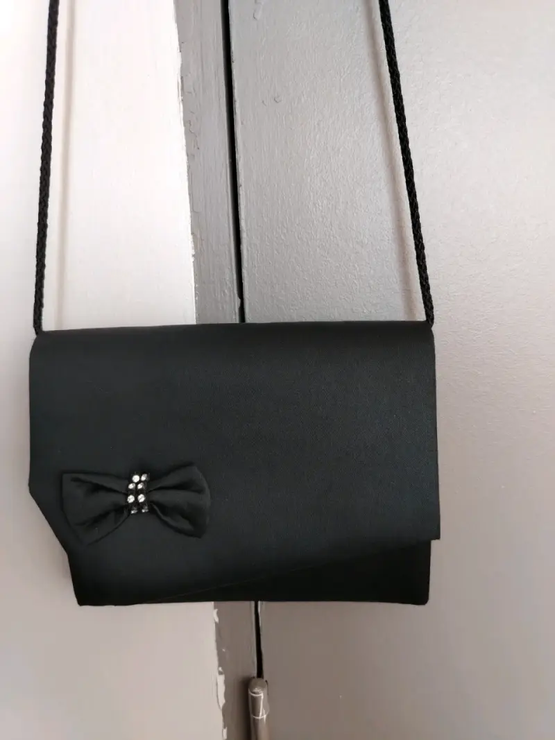 Elegante cartera de mano negra con lazo decorativo - 1