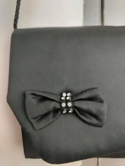 Elegante cartera de mano negra con lazo decorativo - miniatura 2