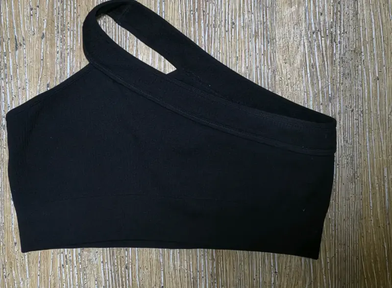 Top deportivo negro de un solo hombro