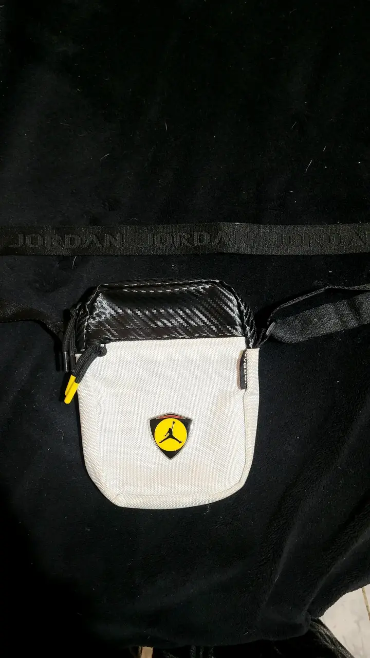 Riñonera Jordan blanca con logo negro y amarillo