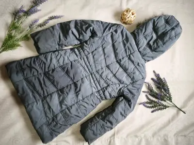 Chaqueta acolchada gris con capucha de piel sintética - miniatura 2
