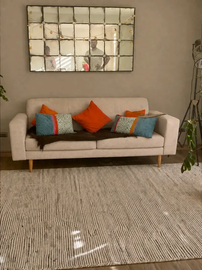 Sofá beige moderno con cojines decorativos