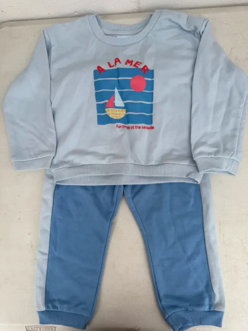 Conjunto de ropa infantil azul con diseño náutico