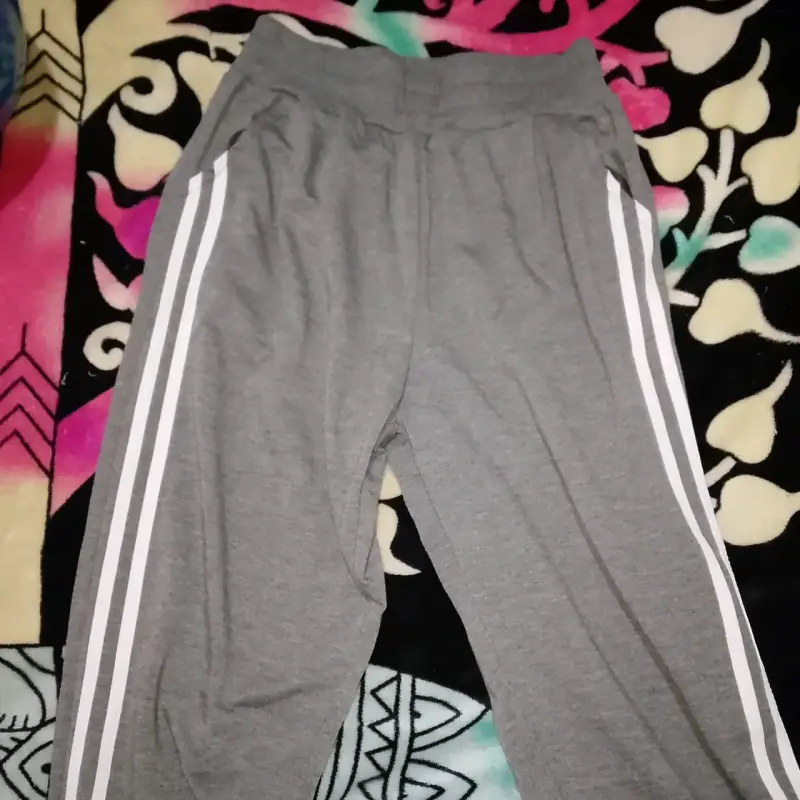 Pantalones deportivos grises con franjas blancas