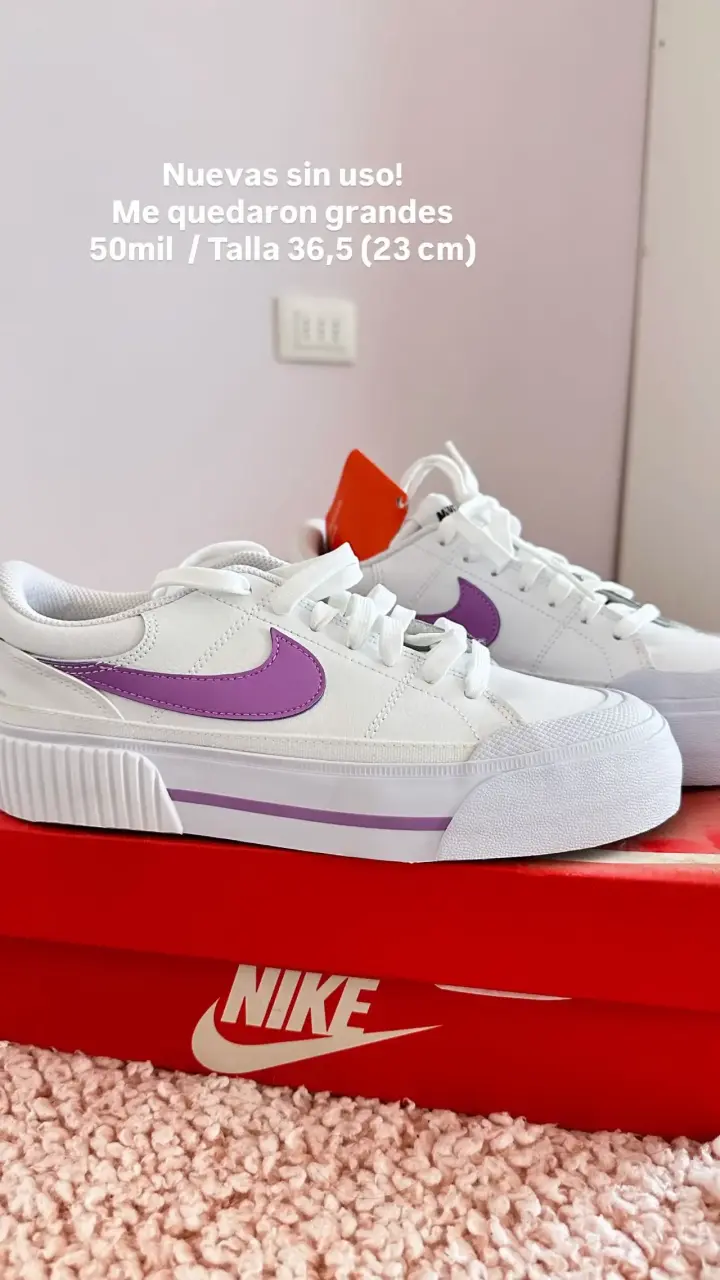 Zapatillas Nike blancas con detalles morados.