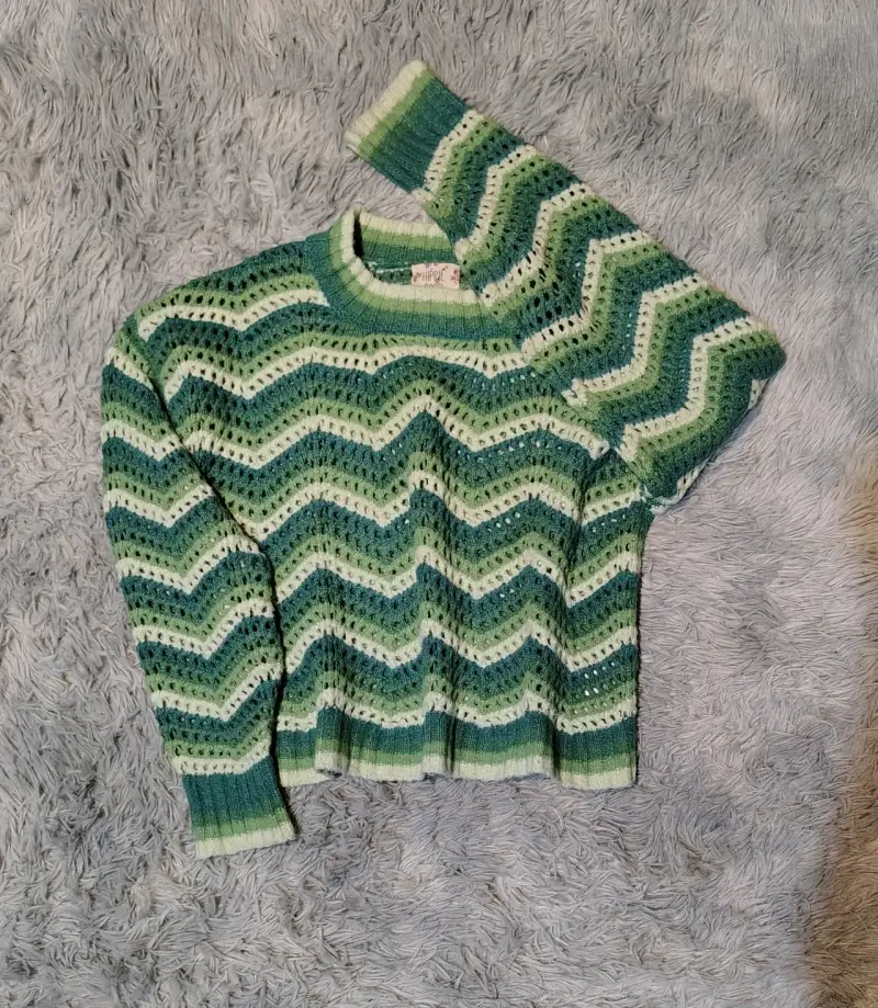 Suéter tejido a crochet verde con diseño zigzag