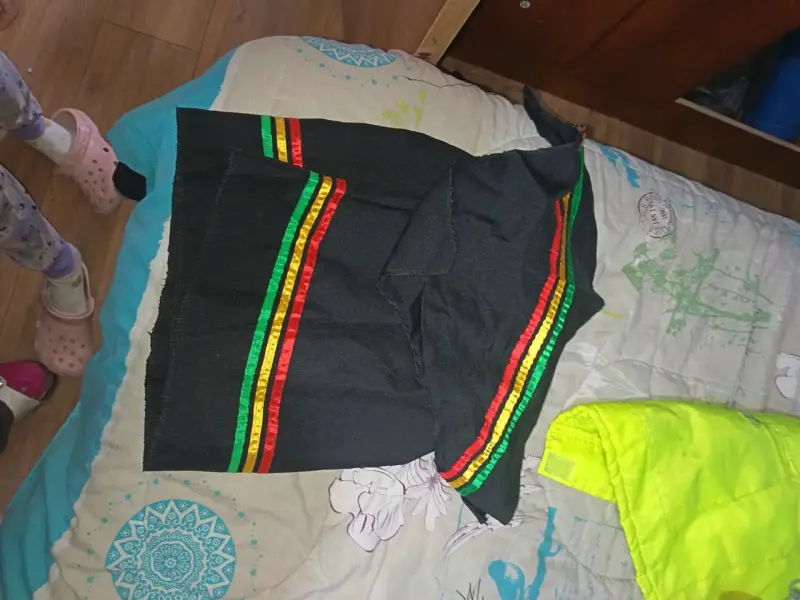 Poncho negro con franjas coloridas estilo Rasta