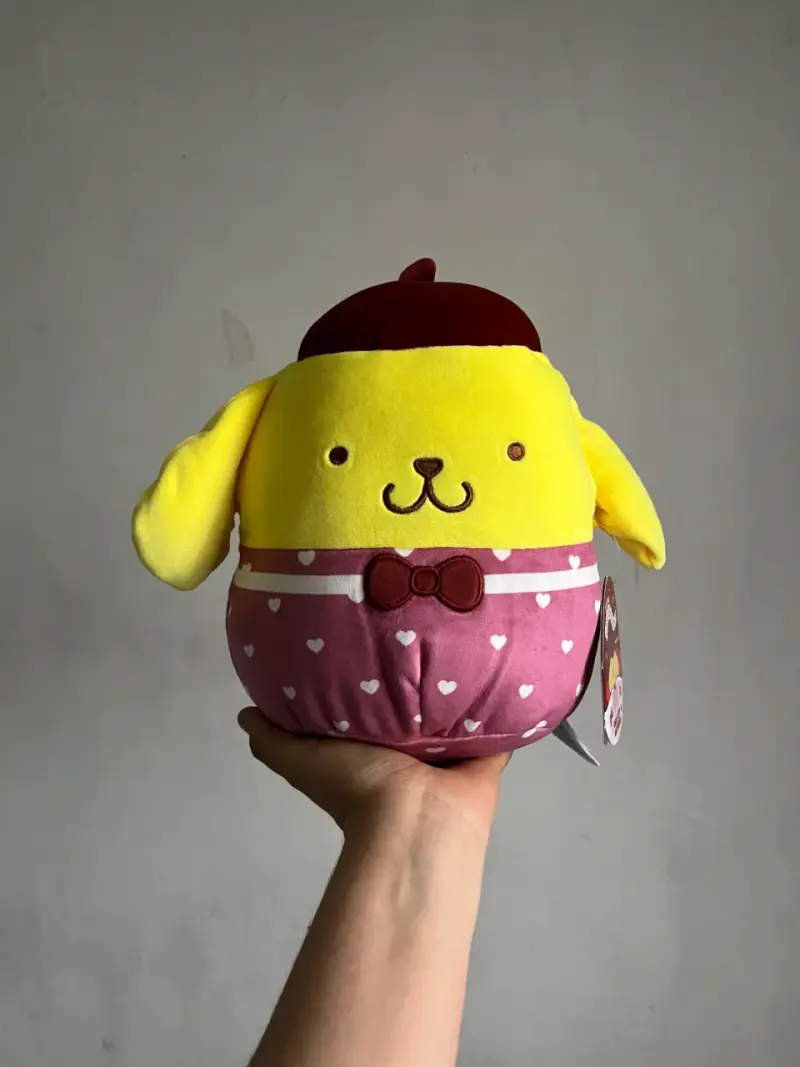Peluche amarillo de perro con sombrero y lazo