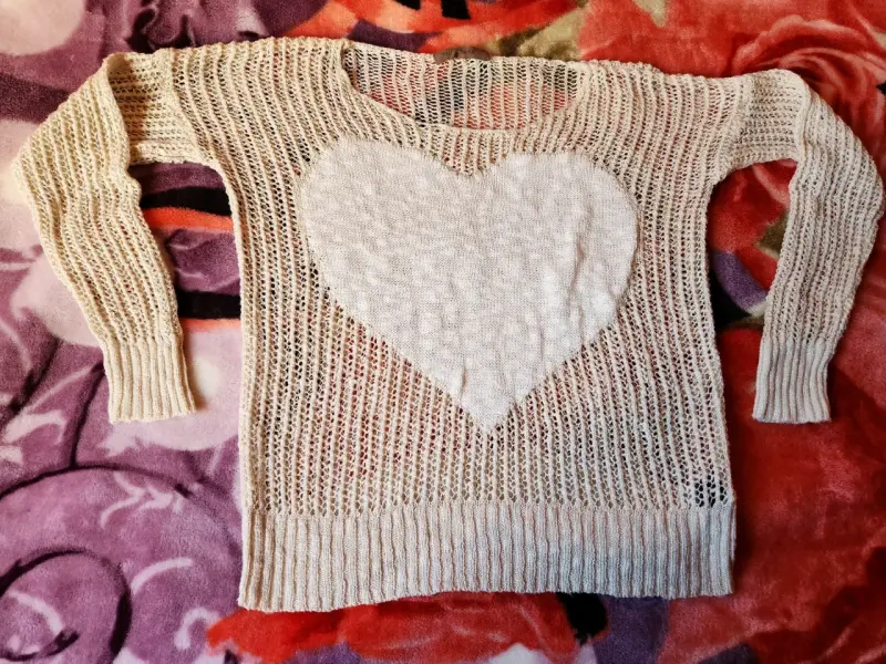Suéter tejido beige con diseño de corazón
