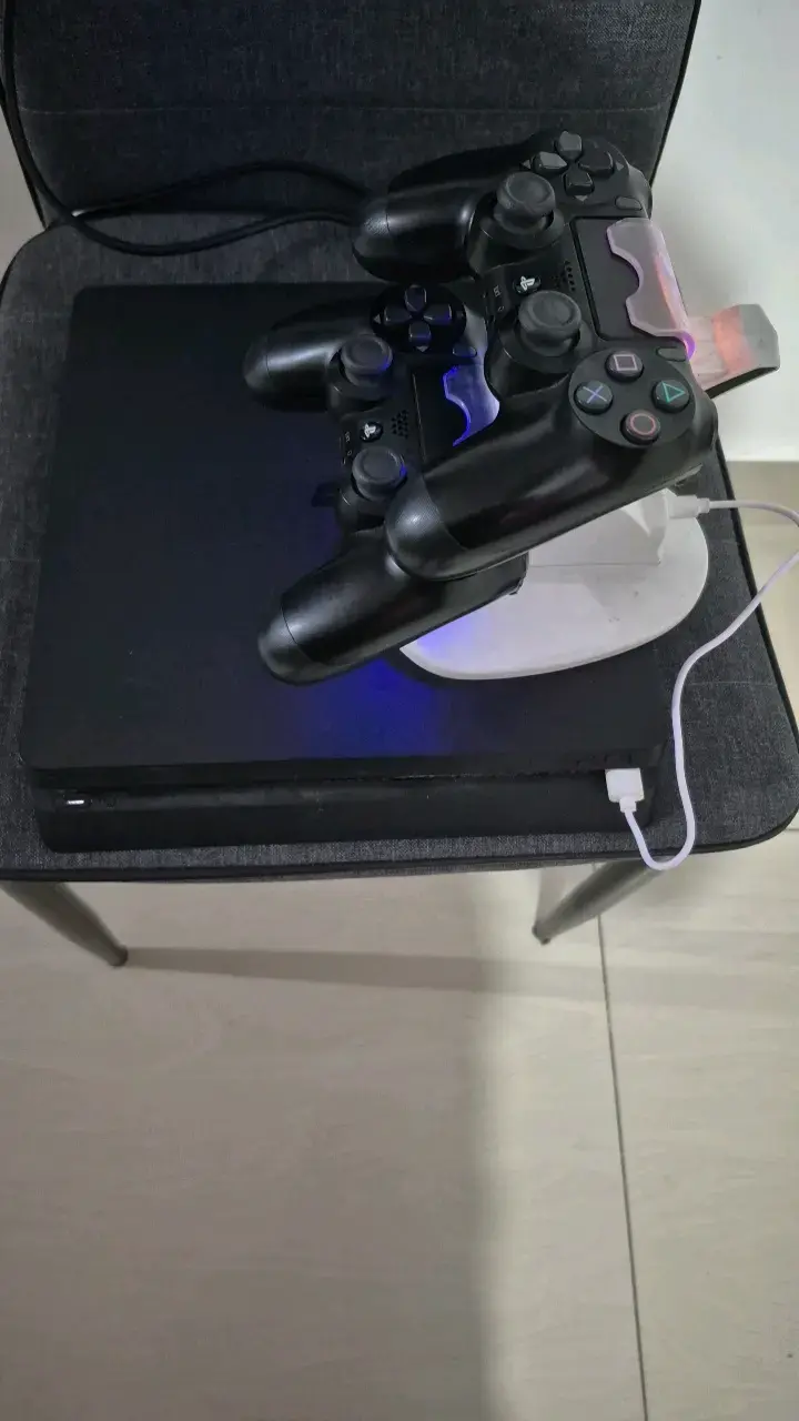 Consola PlayStation 4 con dos controles y base de carga