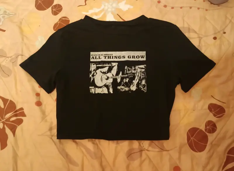 Polera negra con diseño gráfico 'All Things Grow'