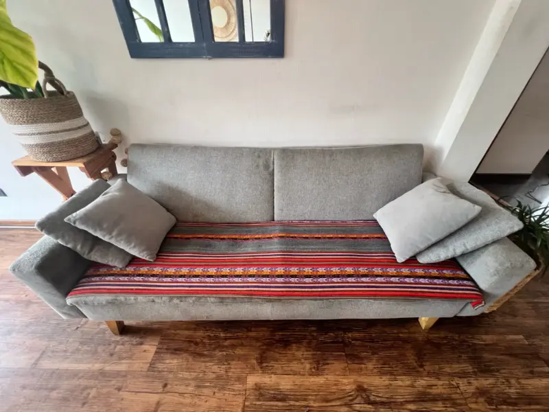 Sofá gris moderno con cojines y manta decorativa - 2