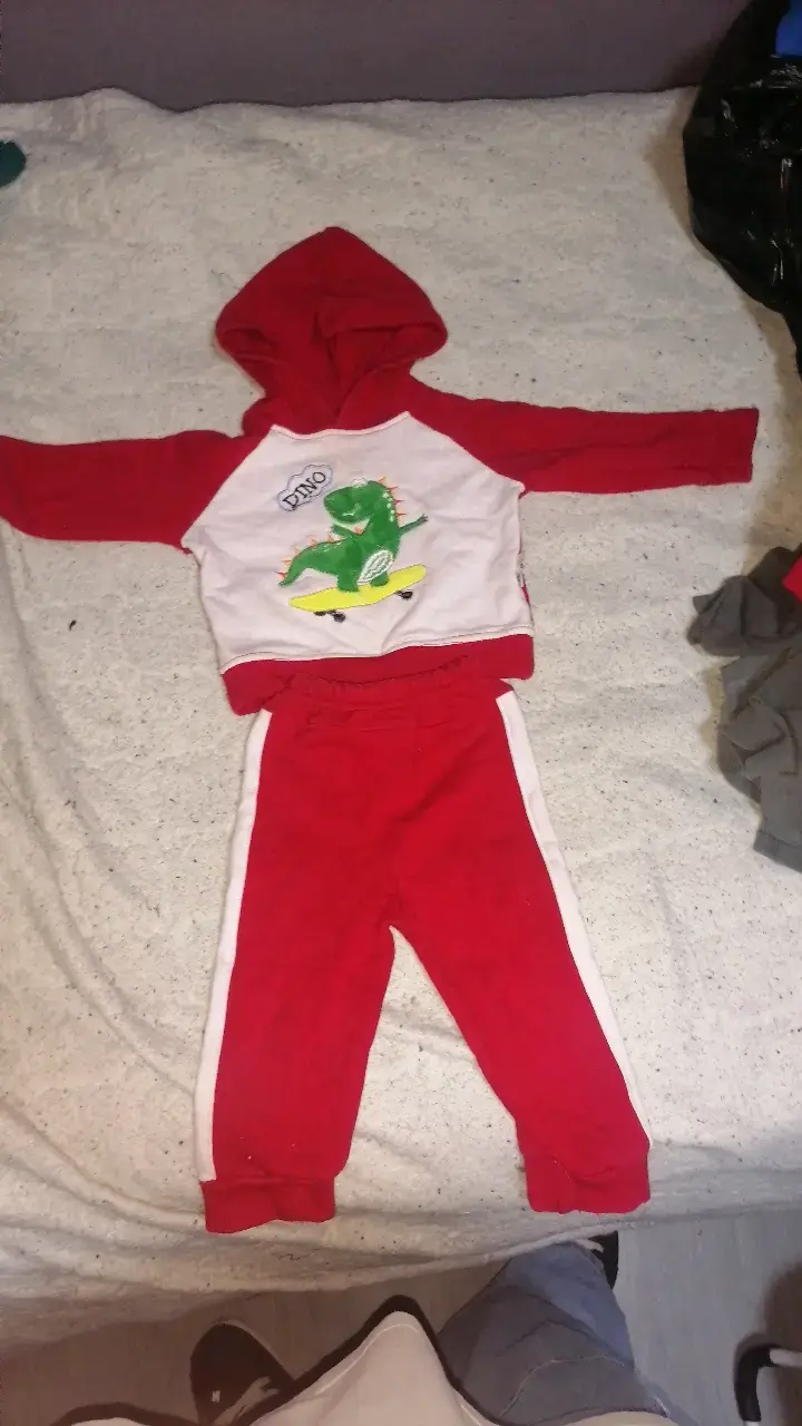 Conjunto de niño rojo con capucha y diseño de dinosaurio