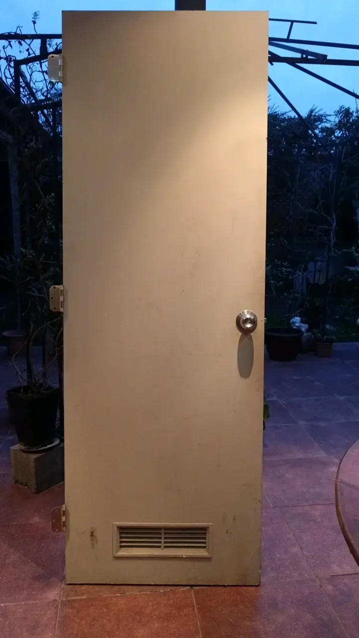 Puerta de madera con ventilación y manilla